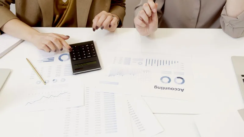 Two accountants reviewing financial reports on a desk