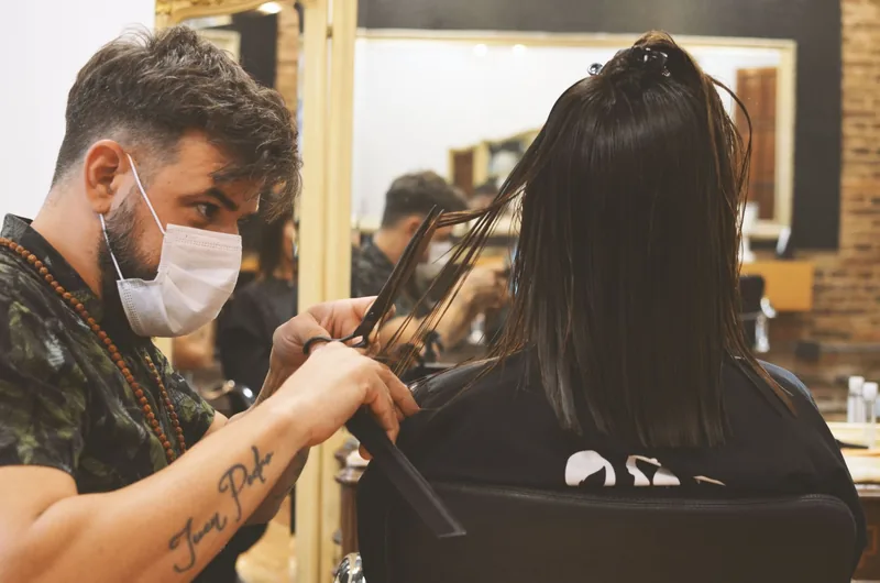 Hairdresser carefully cutting long hair