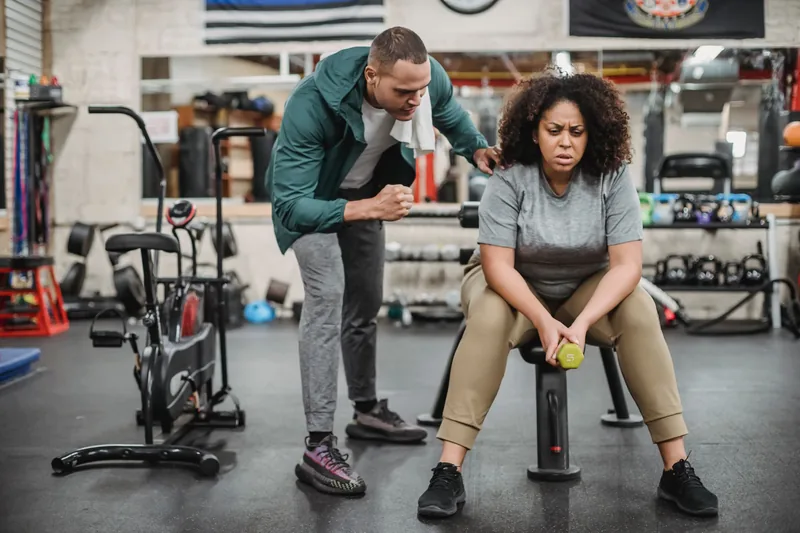 Trainer coaching a client through an exercise in a fitness studio