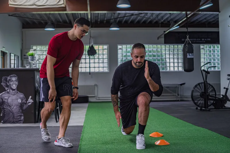 Coach guiding a client through a stretching exercise