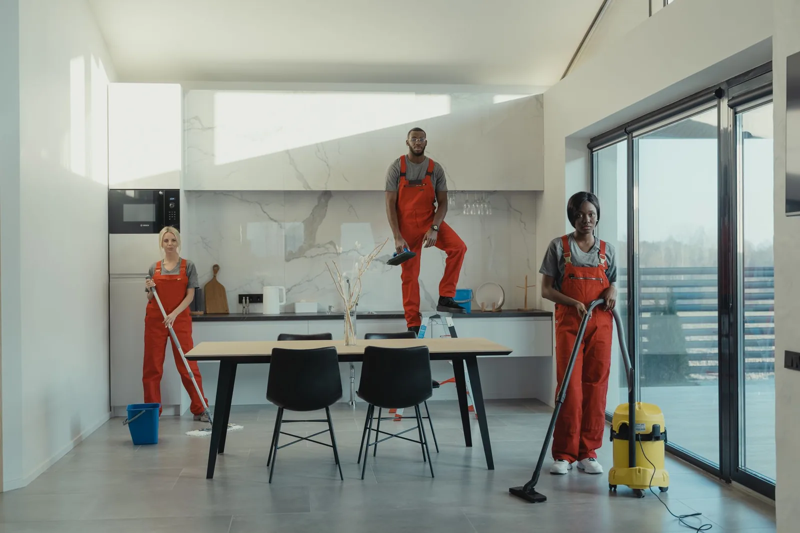 Cleaning crew working together in a bright modern kitchen