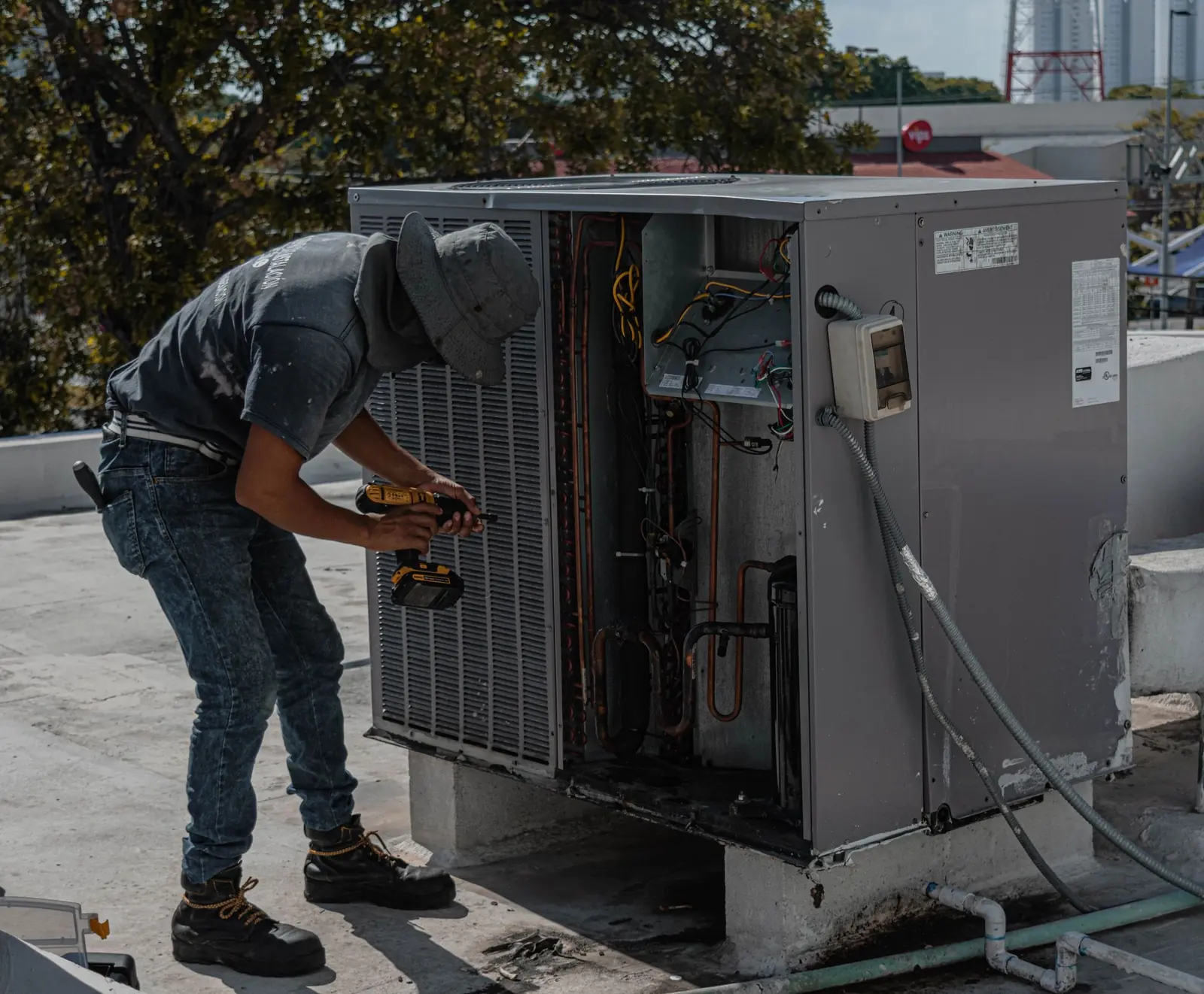 Técnico de HVAC dando servicio a una unidad de aire acondicionado en azotea